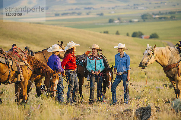 Cowboy und Cowgirls mit Pferden auf einer Ranch
