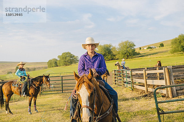 Cowboy beim Reiten auf einer Ranch