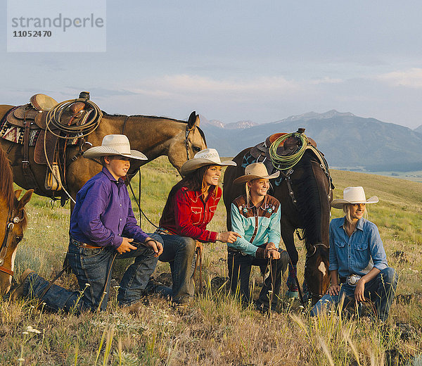 Cowboy und Cowgirls mit Pferden auf einer Ranch