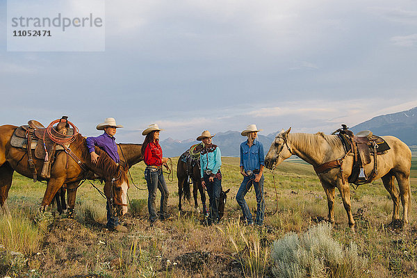 Cowboy und Cowgirls mit Pferden auf einer Ranch