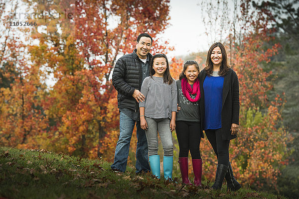 Lächelnde Familie auf einem Herbsthügel