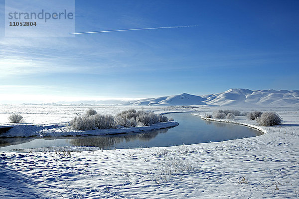 Schneebedeckte Berge und Fluss in abgelegener Landschaft