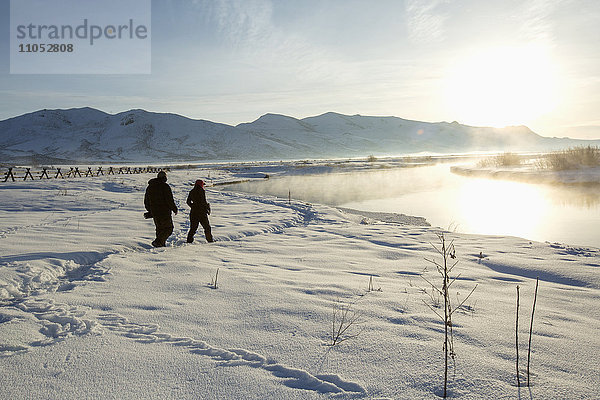 Kaukasisches Paar geht in verschneiter Landschaft spazieren