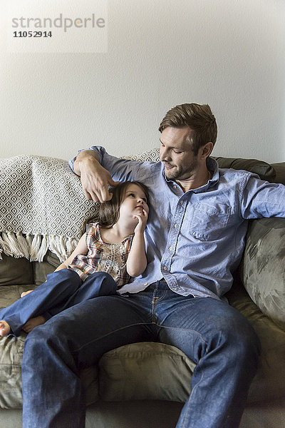 Vater und Tochter sitzen auf dem Sofa