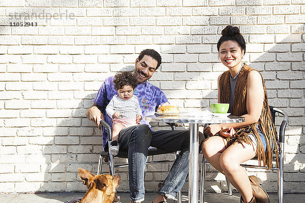 Eltern essen mit ihrem kleinen Sohn in einem Straßencafé