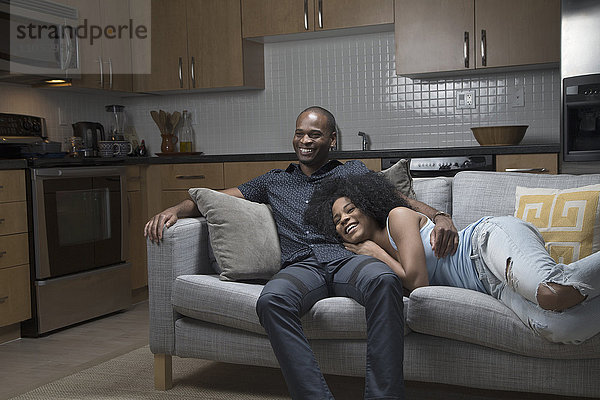Afroamerikanisches Paar entspannt auf Sofa