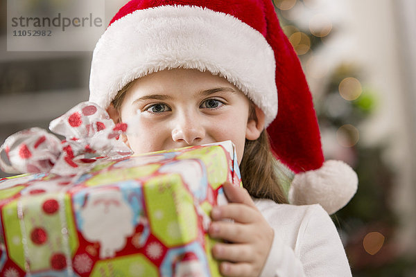 Kaukasisches Mädchen hält Weihnachtsgeschenk