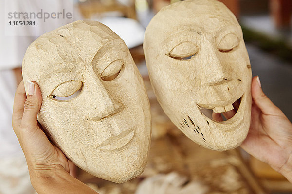 Zwei traditionelle hölzerne Gesichtsmasken  frisch geschnitzt.