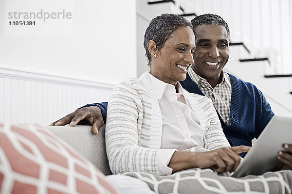 Ein Paar  Mann und Frau  die sich ein digitales Tablett teilen.