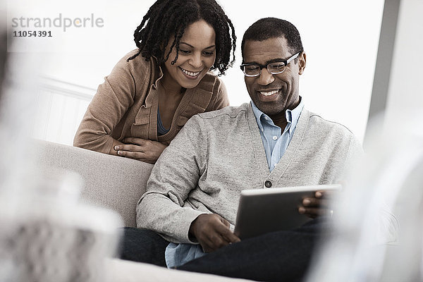 Ein Paar  Mann und Frau  die sich ein digitales Tablett teilen.