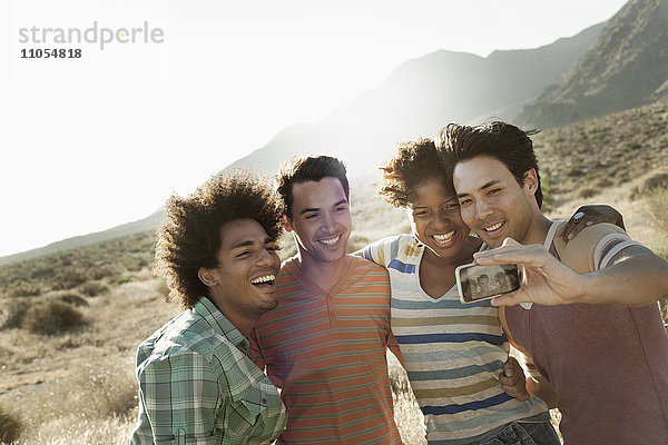 Eine Gruppe von Freunden  Männer und Frauen  geht gemeinsam in der Hitze des Tages für ein Selfy in Pose.