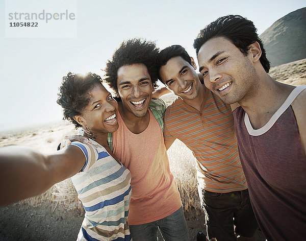 Eine Gruppe von Freunden  Männer und Frauen  geht gemeinsam in der Hitze des Tages für ein Selfy in Pose.