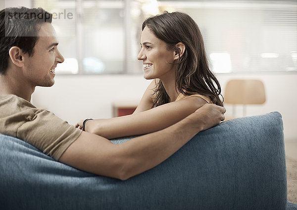 Ein junges Paar  das auf einem Sofa sitzt und sich gegenseitig anstarrt  ein Mann und eine Frau  Freund und Freundin.
