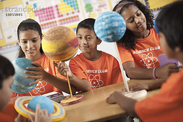 Eine Gruppe von Mädchen und Jungen  die das T-Shirt des Science Club tragen und Molekularstrukturmodelle anfertigen.