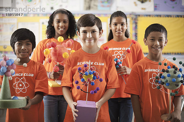 Eine Gruppe von Mädchen und Jungen  die das T-Shirt des Science Club tragen und Molekularstrukturmodelle anfertigen.