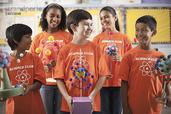 Eine Gruppe von Mädchen und Jungen  die das T-Shirt des Science Club tragen und Molekularstrukturmodelle anfertigen.