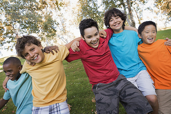 Fünf Kinder  Jungen laufen mit den Armen umeinander.