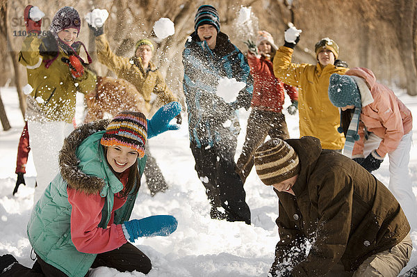 Eine Gruppe von Jugendlichen  Jungen und Mädchen  die eine Schneeballschlacht veranstalten.
