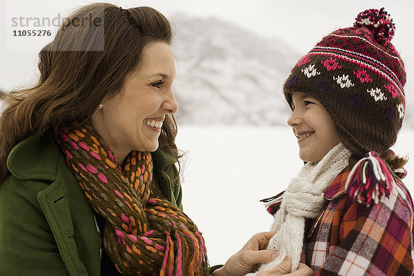 Eine Frau und ein kleines Kind in den verschneiten Bergen.