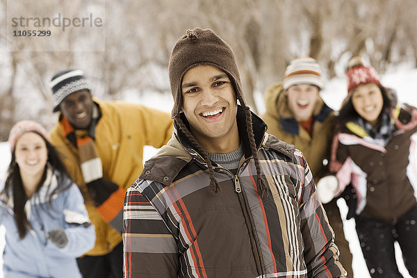 Fünf junge Leute  Männer und Frauen  rennen über den Schnee.