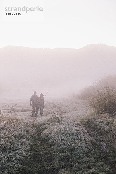 Zwei Menschen  ein Mann und eine Frau  die an einem frostigen Morgen einen Weg entlanglaufen.