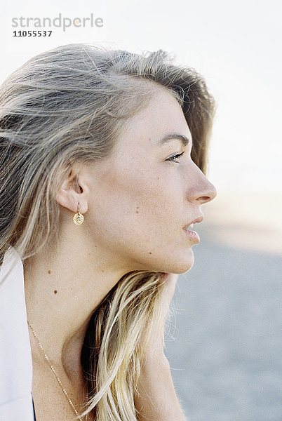 Eine Frau mit langen blonden Haaren  Profil.