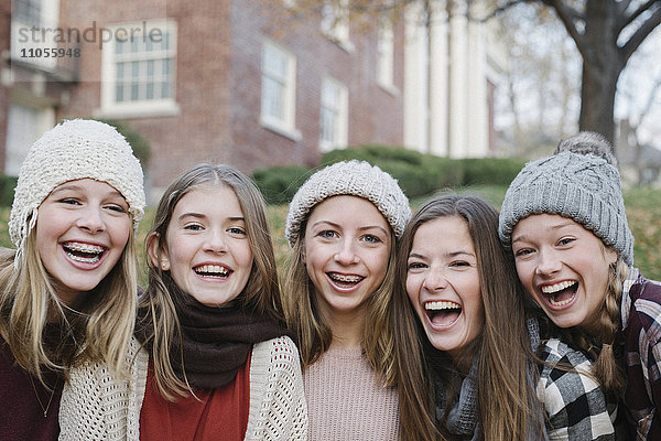 Eine Gruppe von fünf Teenager-Mädchen im Freien mit Wollmützen und Schals.