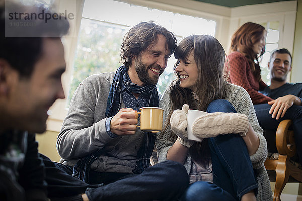 Eine Gruppe von Männern und Frauen  die sich mit heißen Getränken aufwärmen.