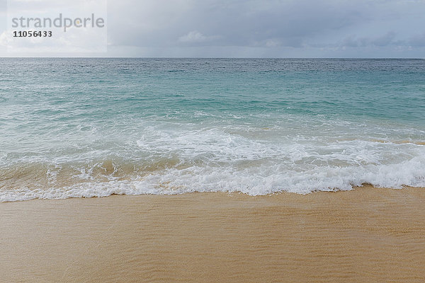 Brechende Wellen auf dem Sand an der Küste des Pazifischen Ozeans.