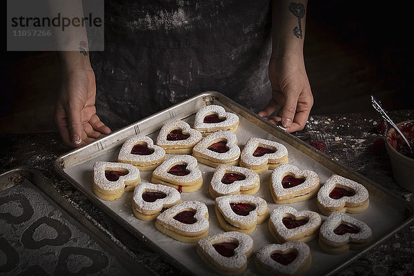 Valentinstag-Backen  Hochwinkelansicht eines Backblechs mit herzförmigen Keksen.