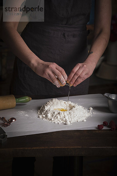 Valentinstag beim Backen  Frau steht in einer Küche und bereitet Teig für Kekse vor.