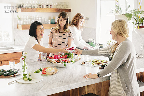 Vier Frauen in einer Küche bei der Zubereitung des Mittagessens.