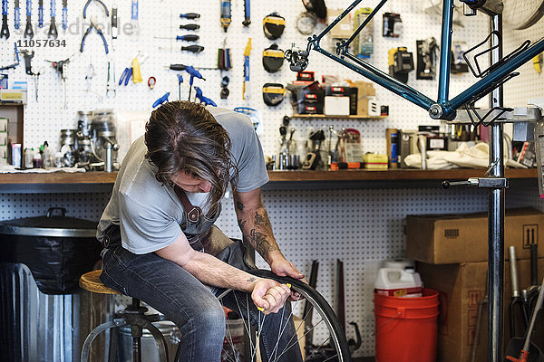 Ein Mann  der in einer Fahrradwerkstatt arbeitet.