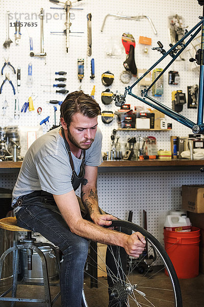 Ein Mann  der in einer Fahrradwerkstatt arbeitet.