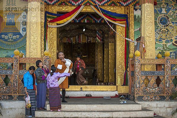 Traditionell gekleidete Familie am Tempeleingang im Dzong  Punakha  Himalaya-Region  Königreich Bhutan