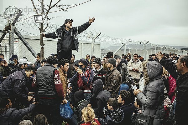Flüchtlingslager Idomeni an der griechisch-mazedonischen Grenze  wartende Flüchtlinge am Checkpoint  ein Mann übersetzt die offiziellen Informationen  Idomeni  Zentralmakedonien  Griechenland  Europa