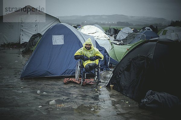 Afghanischer Flüchtling im Rollstuhl  der beide Beine bei einem Bombenattentat verloren hat  Flüchtlingslager Idomeni  Grenze zu Mazedonien  Griechenland  Europa