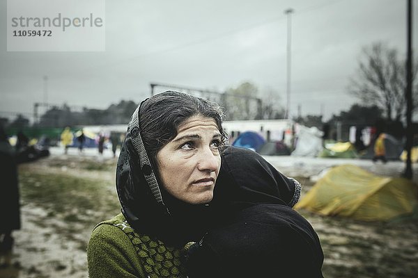 Mutter mit kleinem Kind auf dem Arm  Flüchtlingslager Idomeni  Grenze zu Mazedonien  Griechenland  Europa