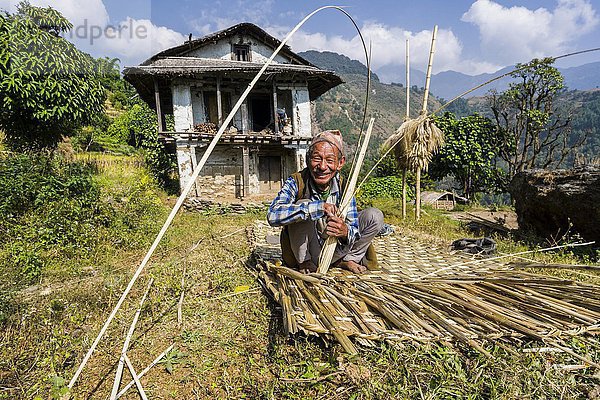 Mann webt einen Bambusmatte als Zaun vor seinem Bauernhaus  Bung  Solo Khumbu  Nepal  Asien