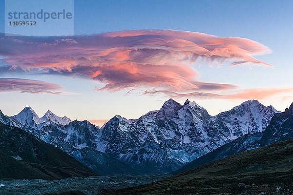 Rosa Wolke über schneebedeckter Bergkette bei Sonnenuntergang  Lobuche  Solo Khumbu  Nepal  Asien
