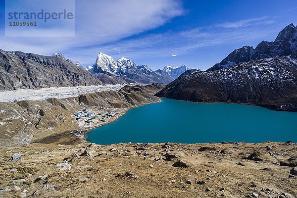 Ausblick auf den See und das Dorf Gokyo von Gokyo Ri aus  der Ngozumba Gletscher und schneebedeckte Berge in der Ferne  Gokyo  Solo Khumbu  Nepal  Asien