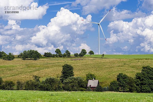 Windkraftanlage und ein kleines Haus zwischen Wiesen  Hermsdorf  Sachsen  Deutschland  Europa