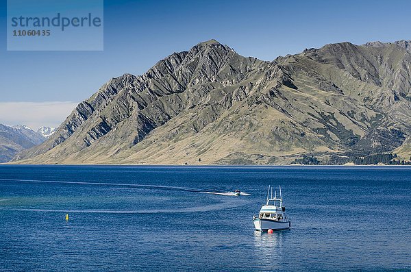 Motorboote auf dem See Lake Hawea unter blauem Himmel  hinten Dingle Burn Gebirge  Otago  Neuseeland  Ozeanien