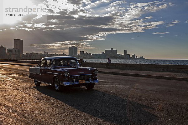 Straßenszene  Oldtimer fährt auf dem Malecon  Abendstimmung  Gegenlicht  Havanna  Kuba  Nordamerika