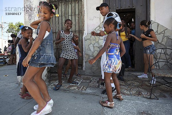 Einheimische Kinder tanzen mit ihrem Tanzlehrer vor einer Tanzschule auf der Straße  Santiago de Cuba  Provinz de Santiago de Cuba  Kuba  Nordamerika