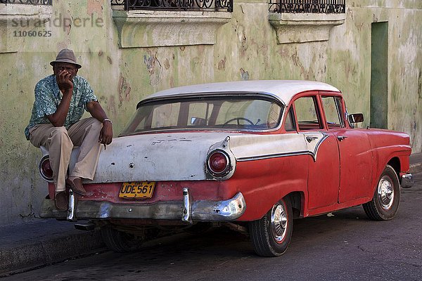 Kubanischer Taxifahrer sitzt auf Oldtimer-Taxi  Santiago de Cuba  Provinz de Santiago de Cuba  Kuba  Nordamerika