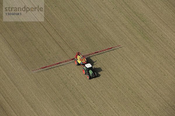 Luftbild  Traktor bei der Aussaat im Frühjahr auf Feld  Agrarlandschaft bei Mühldorf  Oberbayern  Bayern
