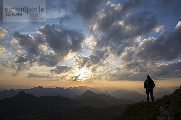 Wanderer schaut in die Ferne  Sonnenaufgang am Krottenkopf  Estergebirge  Blick zum Simetsberg  Herzogstand  Benediktenwand  Garmisch-Partenkirchen  Bayern  Deutschland  Europa