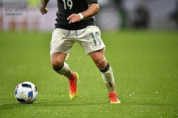 Detail  Beine von Mario Götze  deutscher Fußballspieler  am Ball bei Regen  WWK Arena  Augsburg  Bayern  Deutschland  Europa