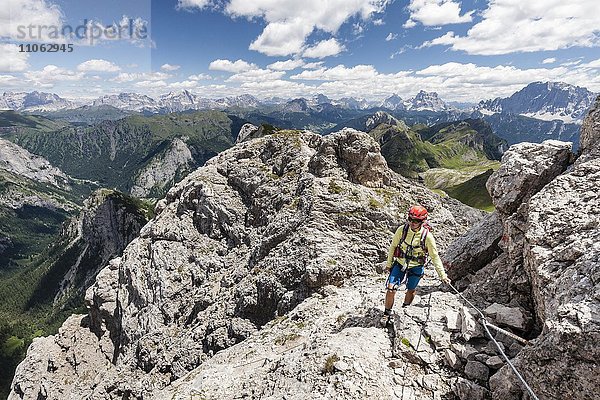 Bergsteigerin beim Aufstieg auf die Cima d'Auta über die Via Ferrata Paolin Piccolin bei Colmean  hinten die Civetta und der Pelmo  Falcade  Klettersteig im Valle del Biois  Dolomiten  Belluno  Italien  Europa
